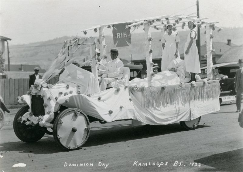 A man rides on a decorated car in 1924