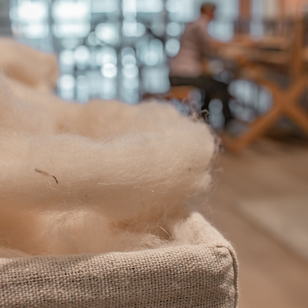 Raw wool, freshly sheared from sheep, is a coarse and tangled mass of fibres filled with natural oils, dirt, and debris. Before it can be spun into yarn, it must go through carding—a process that cleans and aligns the fibres, transforming the wool into a soft, workable material ready for crafting.